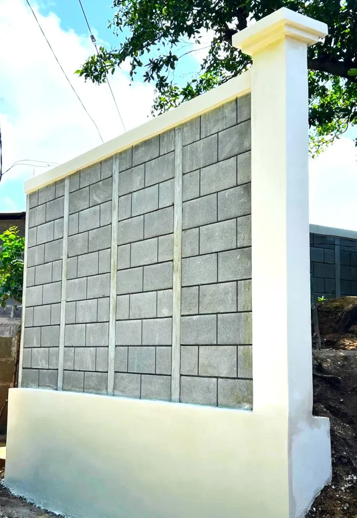 Muro perimetral prefabricado de 2.65 metros de altura terminado con el sistema Maxiblock de ARCON Industrial, postes pretensados de 5,000 PSI y viga corona.
