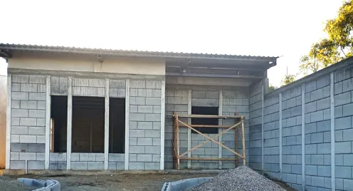 Fachada y muro de viviendas prefabricadas nicaragua en proceso de obra con bloques Maxiblock expuestos y andamios de madera.
