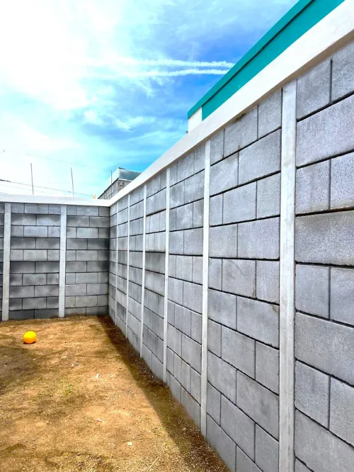 Interior de muro perimetral residencial construido con Sistema Maxiblock de ARCON, mostrando un acabado gris rústico moderno y uniforme.
