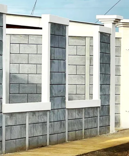 Muro perimetral frontal de estilo residencial con boquetes o aperturas diseñadas para la instalación de verjas metálicas decorativas.