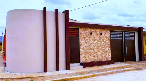 Fachada frontal residencial construida con Sistema Maxiblock de ARCON, acabados decorativos y pintura de color de alta calidad para exteriores.