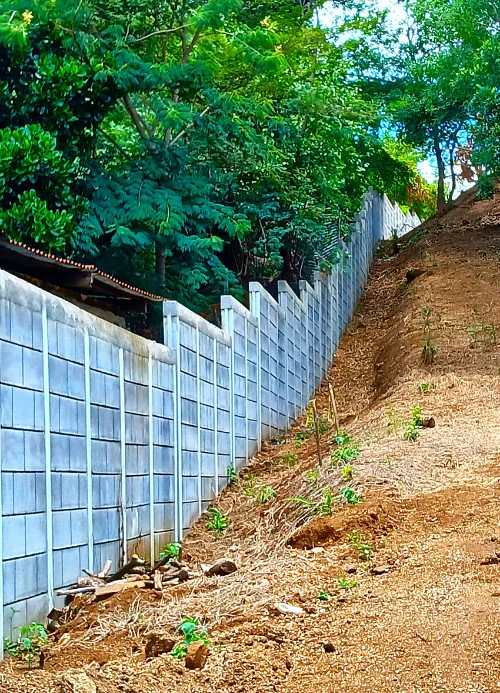 Muro perimetral construido con el sistema prefabricado Maxiblock adaptado perfectamente a una pendiente inclinada del terreno en Nicaragua.